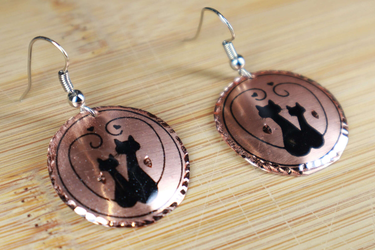 Side angle of handcrafted artisan cat design copper circle earrings