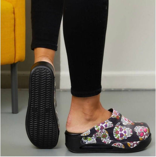 Side profile of handmade skull and flower leather clogs with an Air Clogx sole