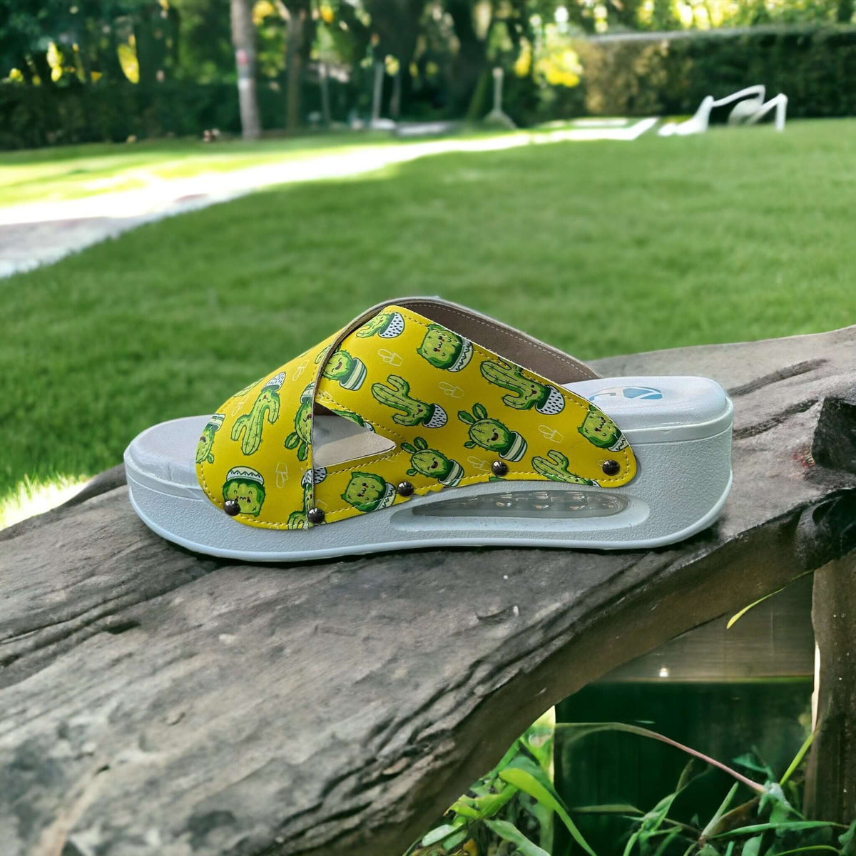 A pair of cactus print cross band leather clog slippers with an Air Clogx sole placed side by side