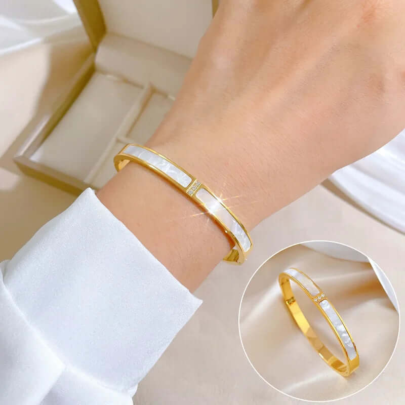 Gold bracelet with white interior on a wrist, with an inset showing a close-up of the bracelet.