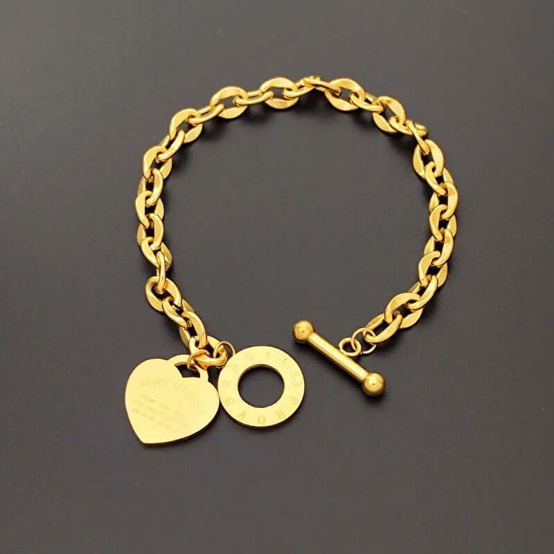 Scale and sizing reference image of heart charm chain bracelet with a steel toggle clasp