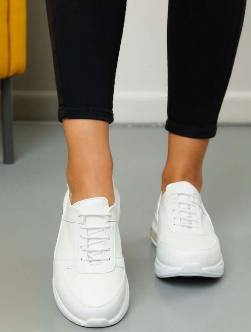 A pair of handmade white leather sneaker clogs with a Supermax sole placed side by side