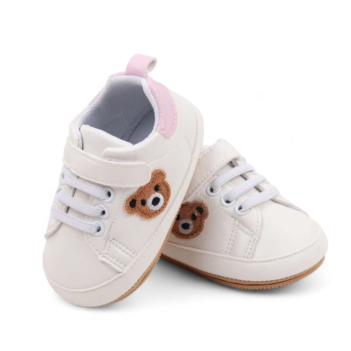 Pink teddy bear baby sneakers with a soft sole worn on the foot