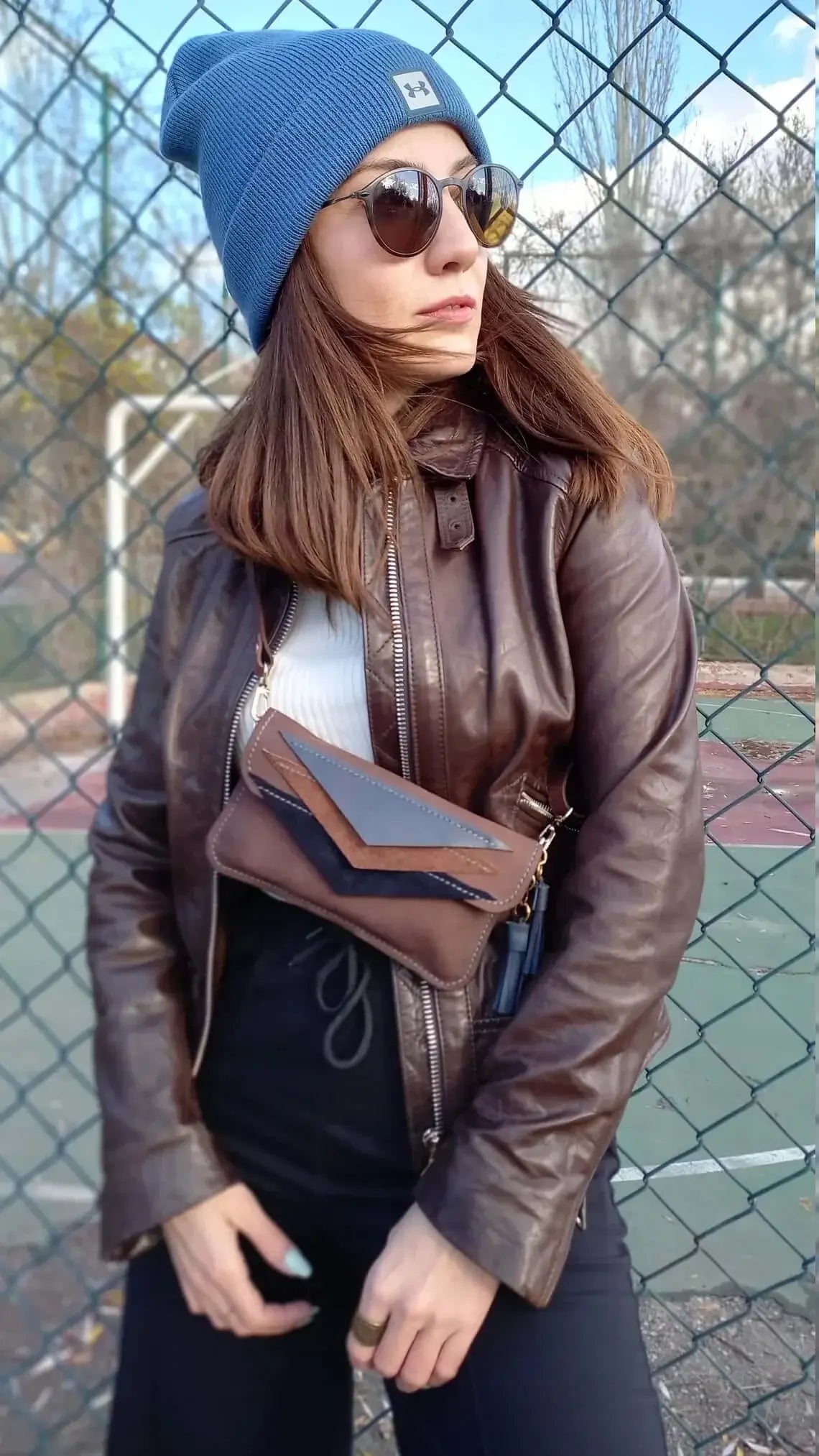 Strap and fastening detail on triangle brown leather belt bum bag