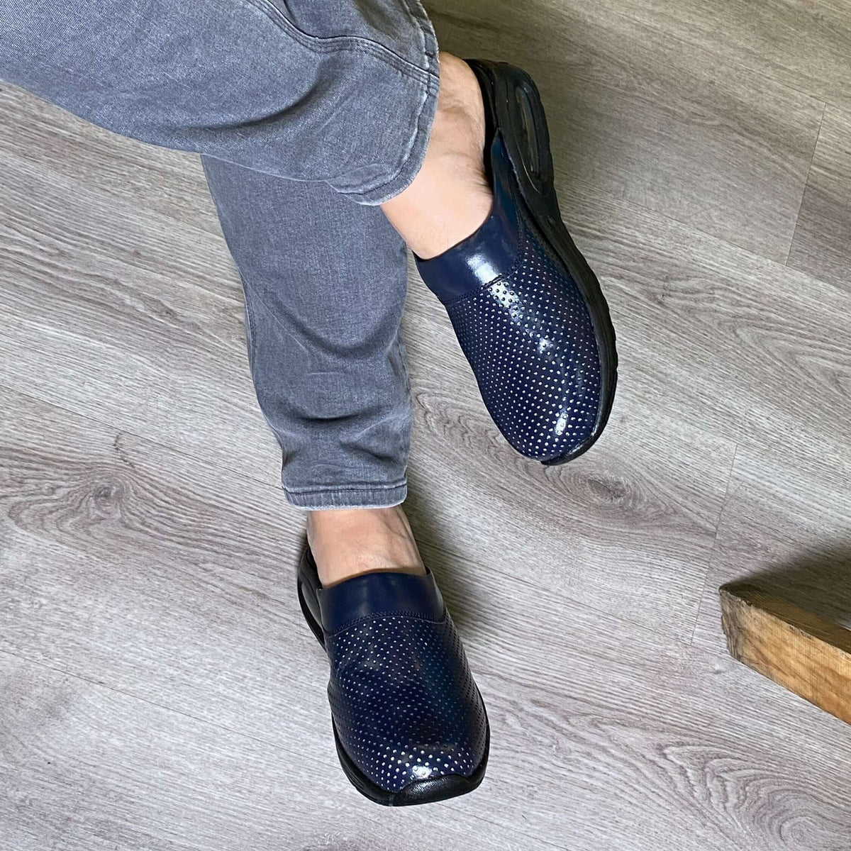 Front view of navy blue leather clogs with a light Air Clogx sole