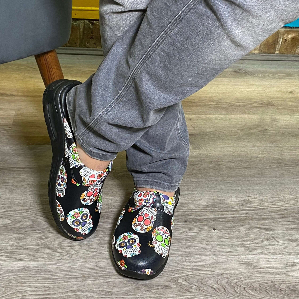 Side profile of unisex skull and flower design leather clogs with a light sole