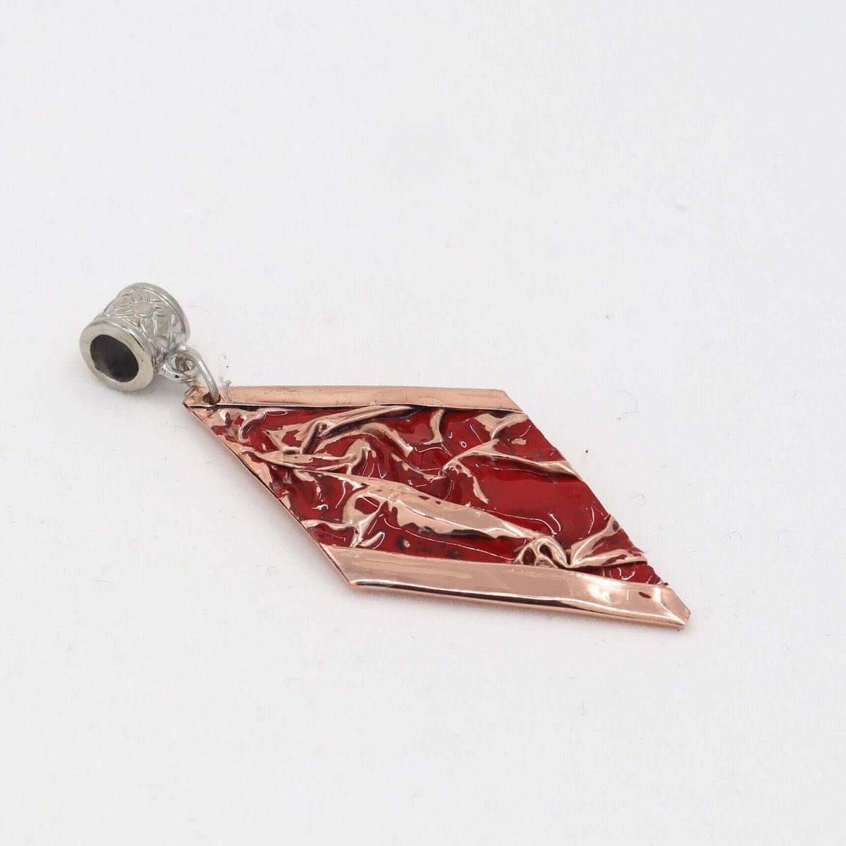 Four-piece red patterned wrinkled copper jewellery set shown next to a hand for scale