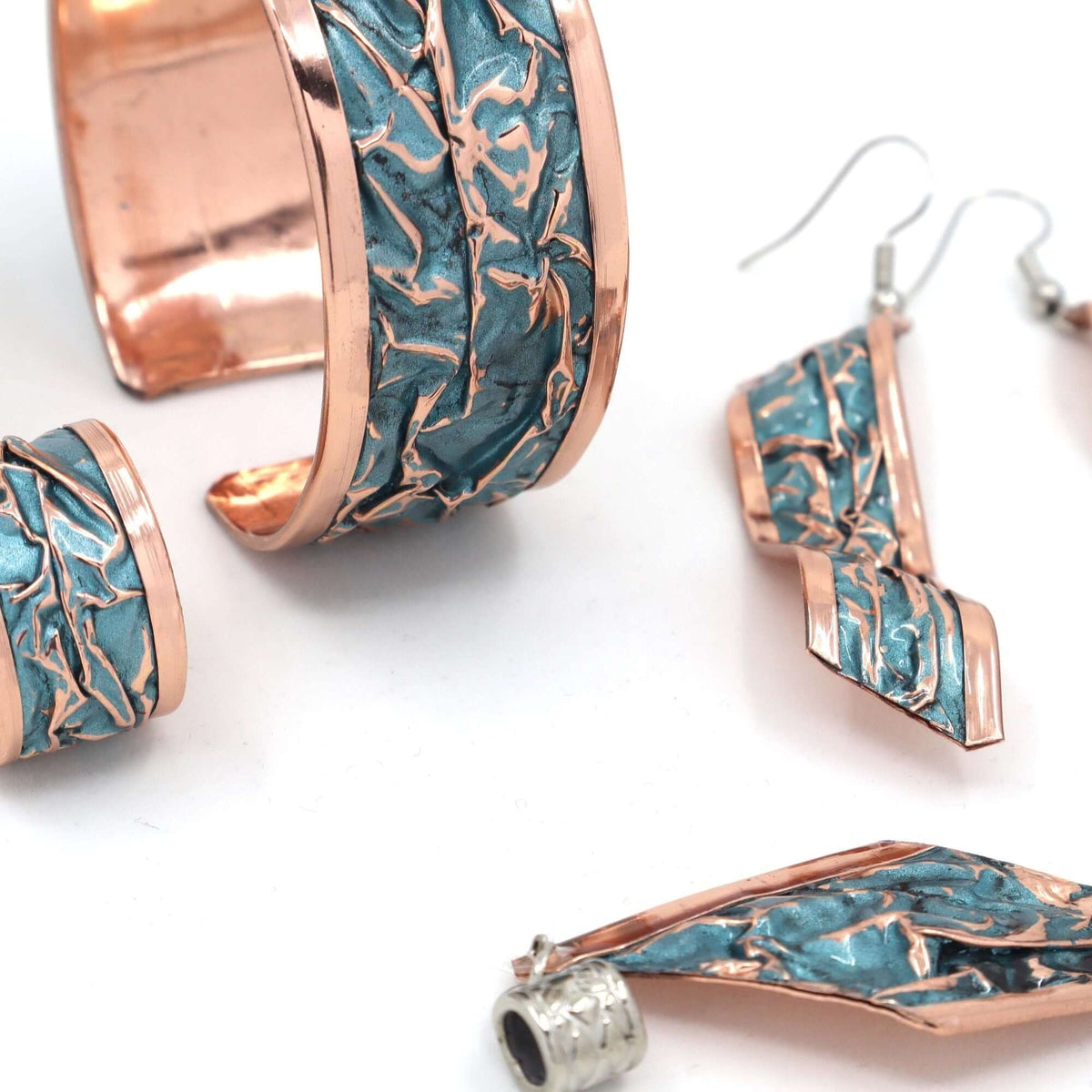 Individual pieces from four-piece turquoise wrinkled copper jewellery set arranged together