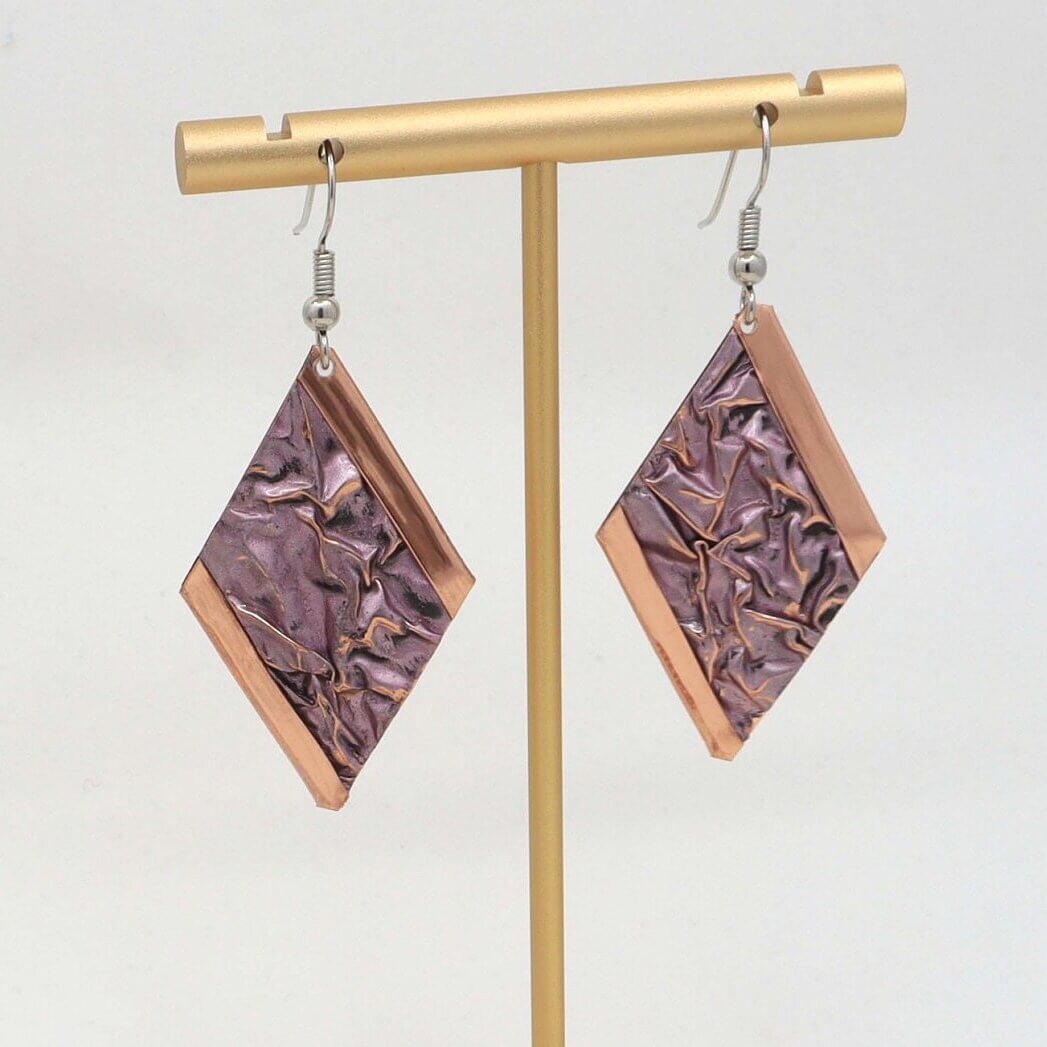 Front view of handcrafted pink wrinkled copper earrings