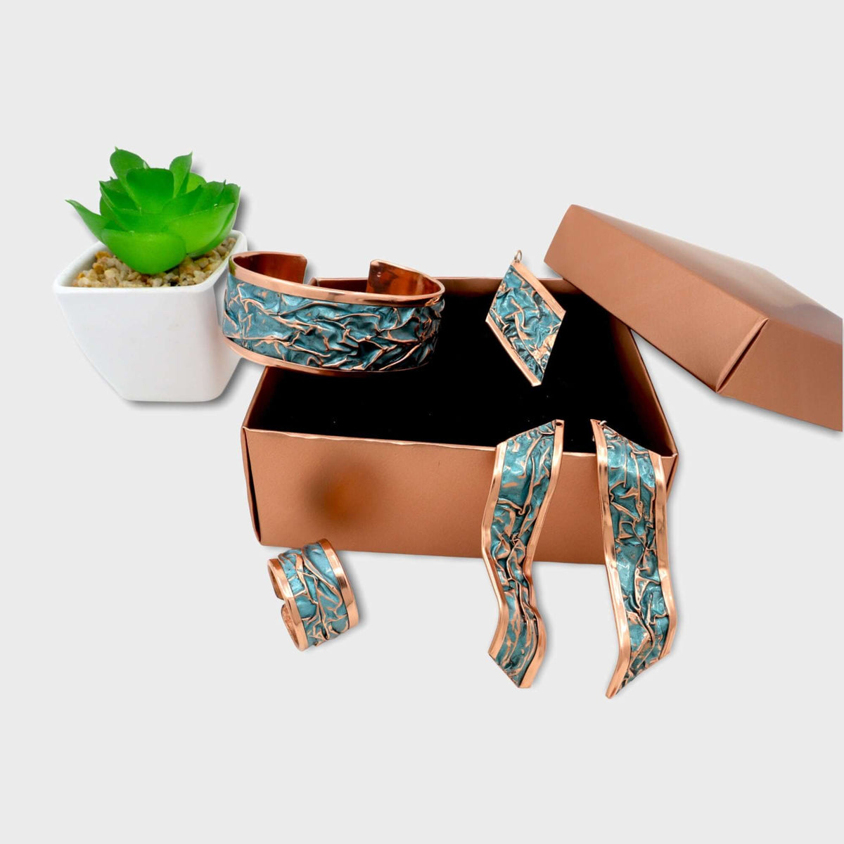 The full four-piece turquoise wrinkled copper jewellery set laid flat