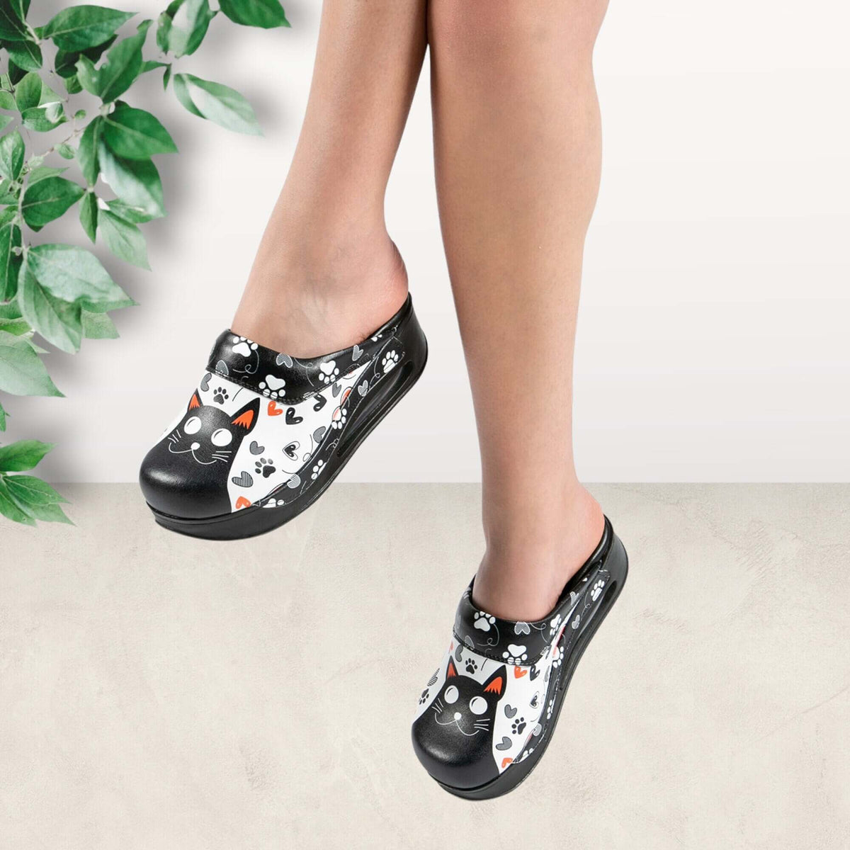 Side profile of handmade black cat design leather clog slippers with an Air Clogx sole
