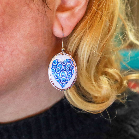Front view of handcrafted blue heart copper circle earrings