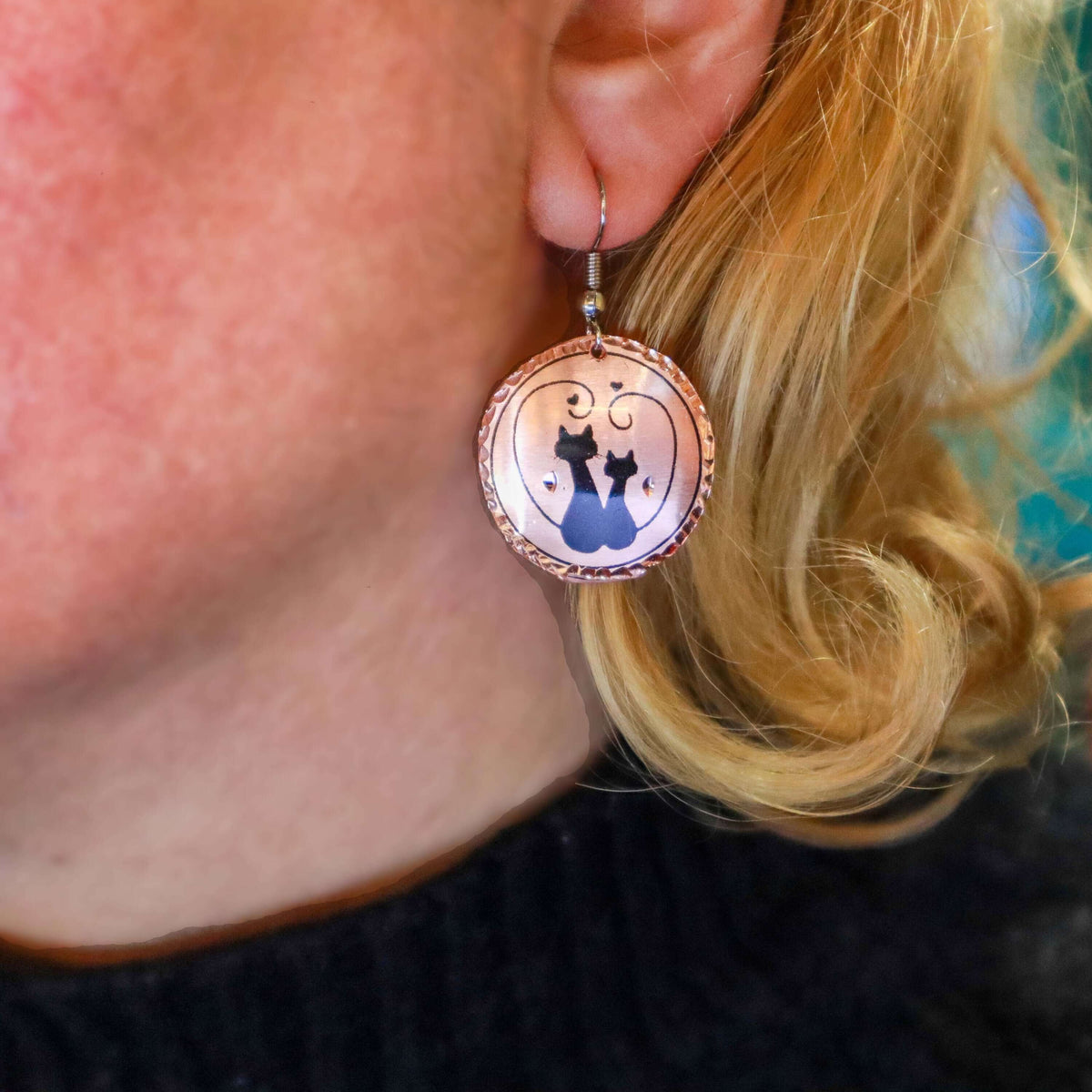 Front view of handcrafted artisan cat design copper circle earrings