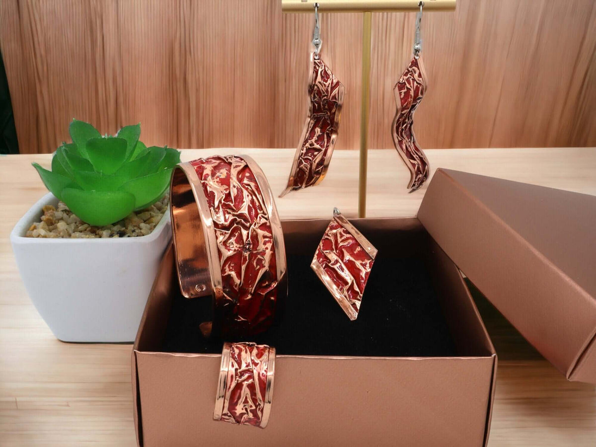 Front view of four-piece red patterned wrinkled copper jewellery set