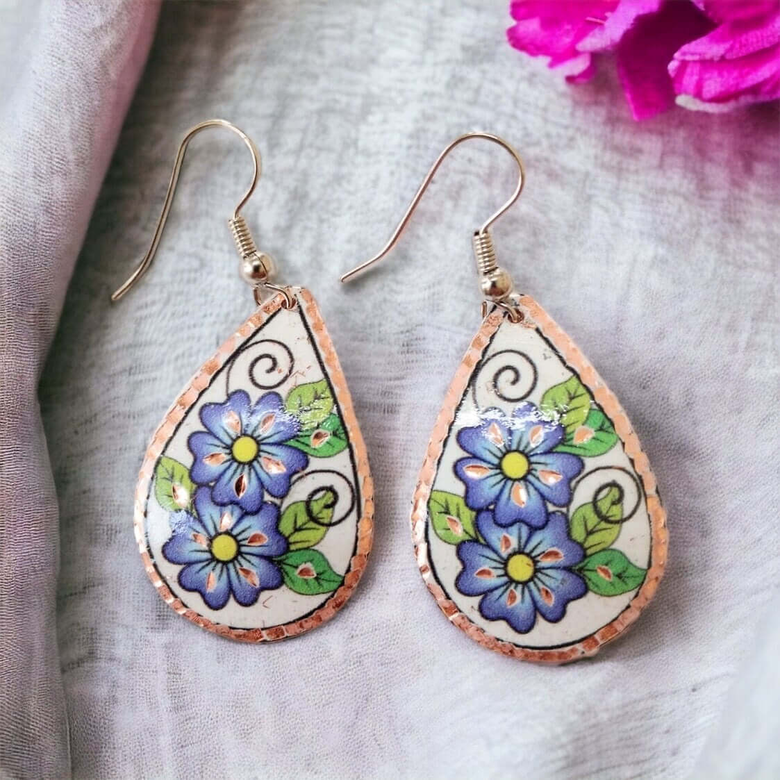 Front view of handmade blue flower drop copper circle earrings