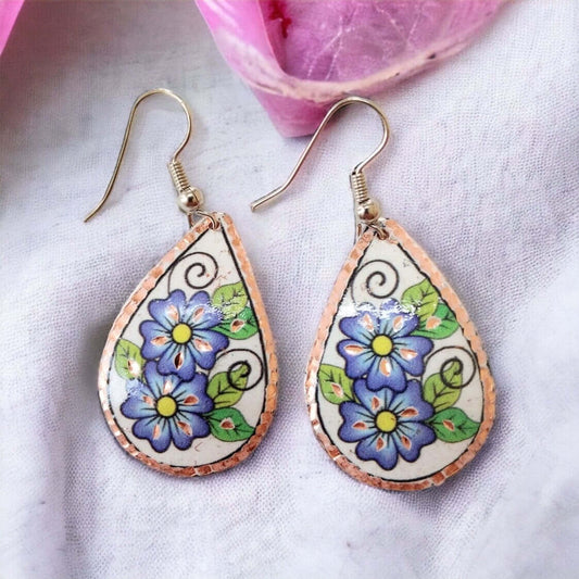 Close-up of the copper texture on handmade blue flower drop copper circle earrings
