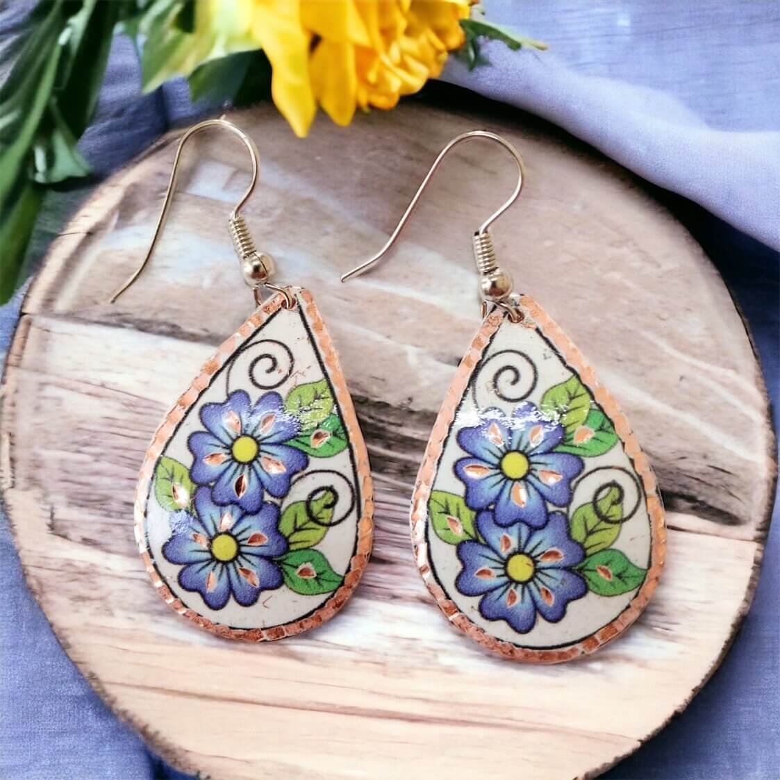 Handmade blue flower drop copper circle earrings worn on the ear