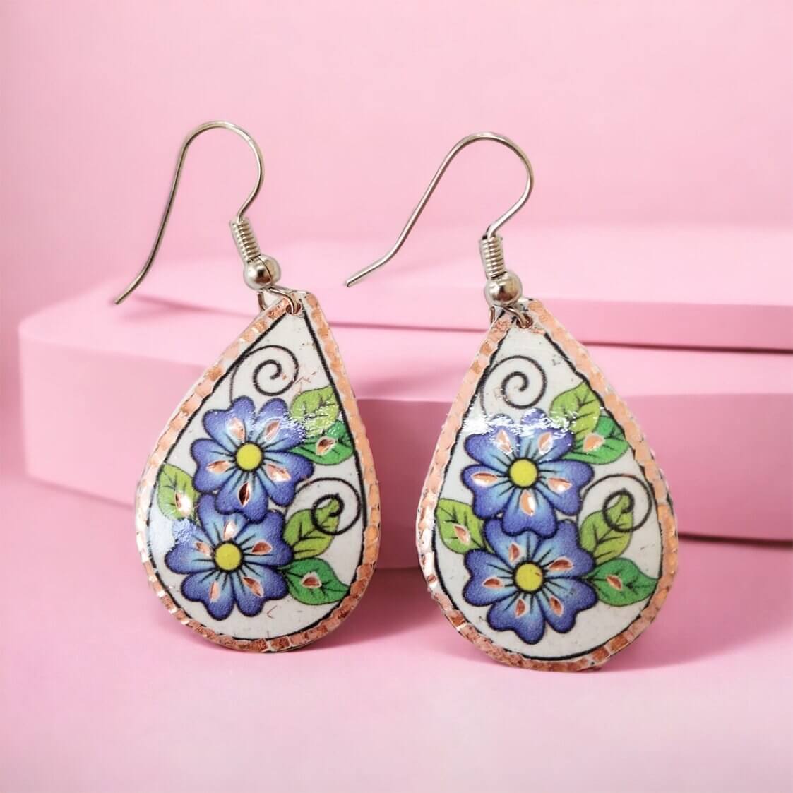 Side angle of handmade blue flower drop copper circle earrings