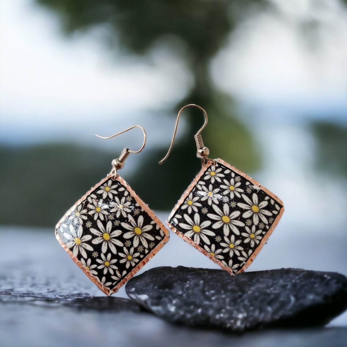 Handcrafted floral daisy copper square earrings worn on the ear