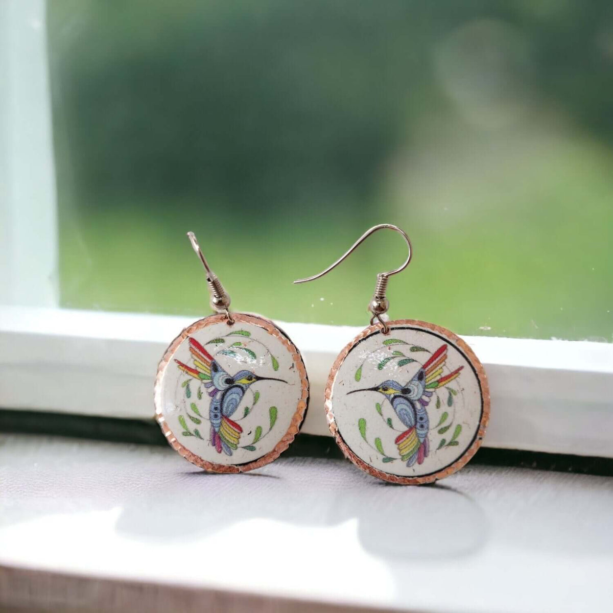 Handcrafted hummingbird copper circle earrings worn on the ear