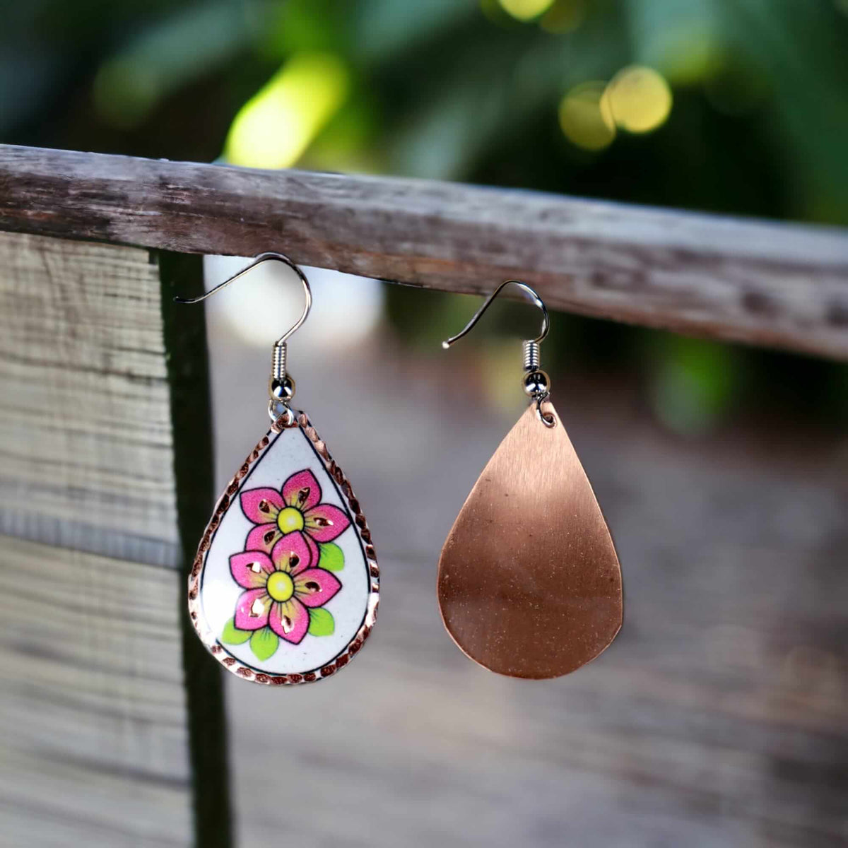 Side angle of handcrafted pink flower copper drop earrings