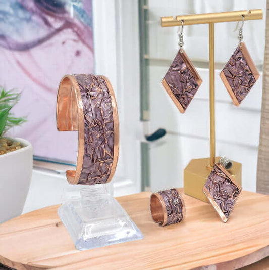 The full four-piece pink wrinkled copper jewellery set laid flat