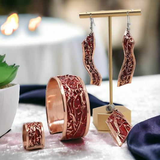 The full four-piece red patterned wrinkled copper jewellery set laid flat