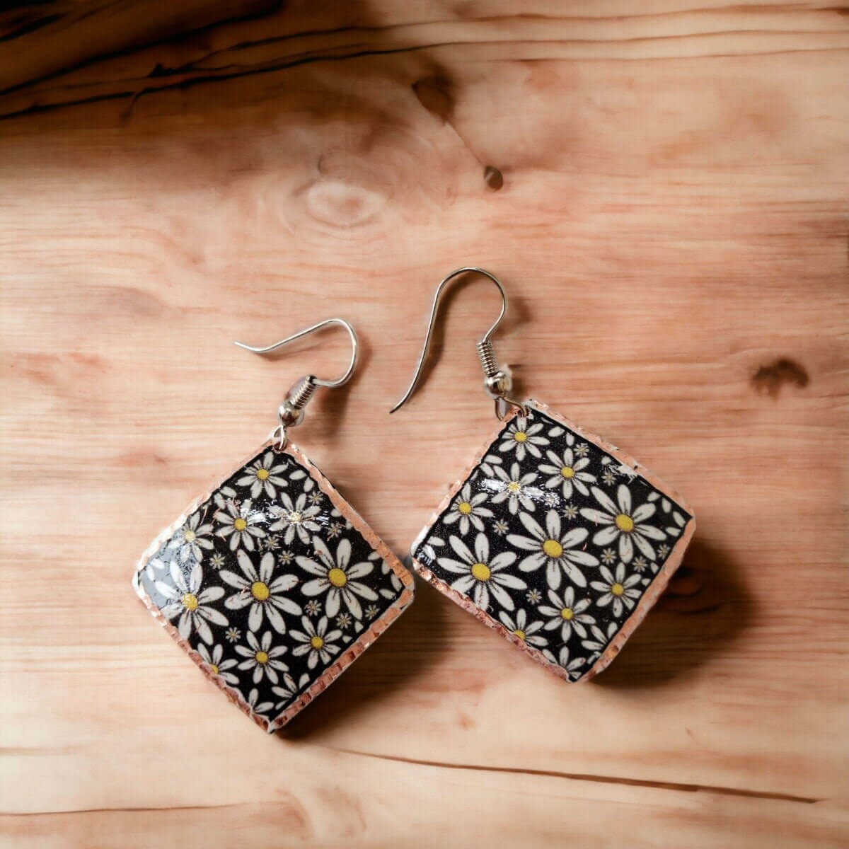 Side angle of handcrafted floral daisy copper square earrings
