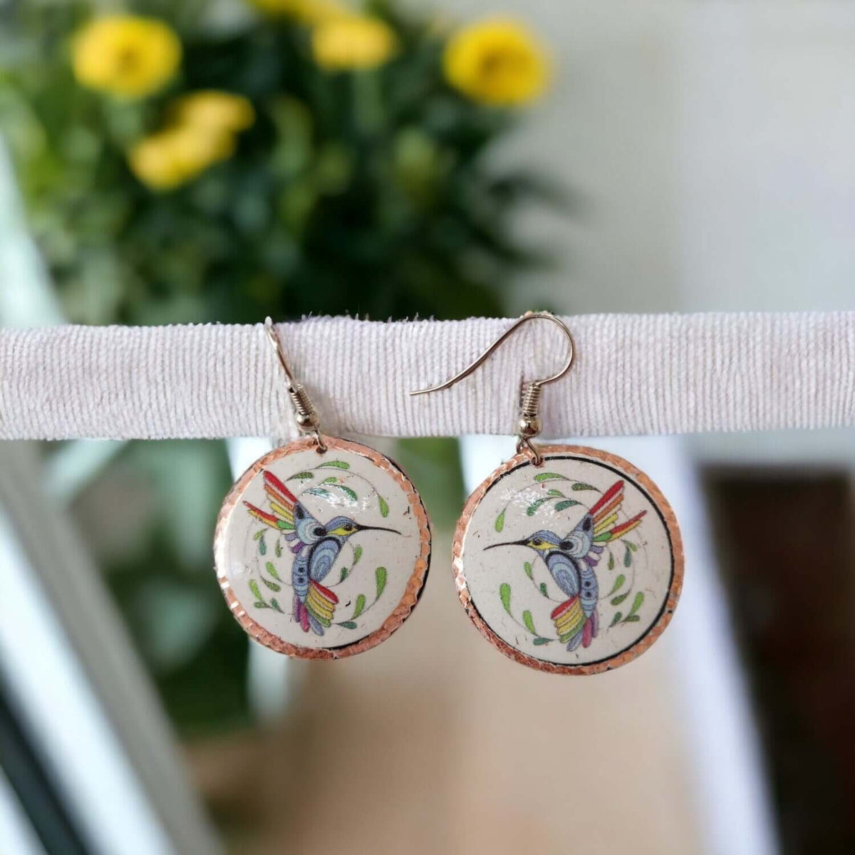 Top-down view of handcrafted hummingbird copper circle earrings