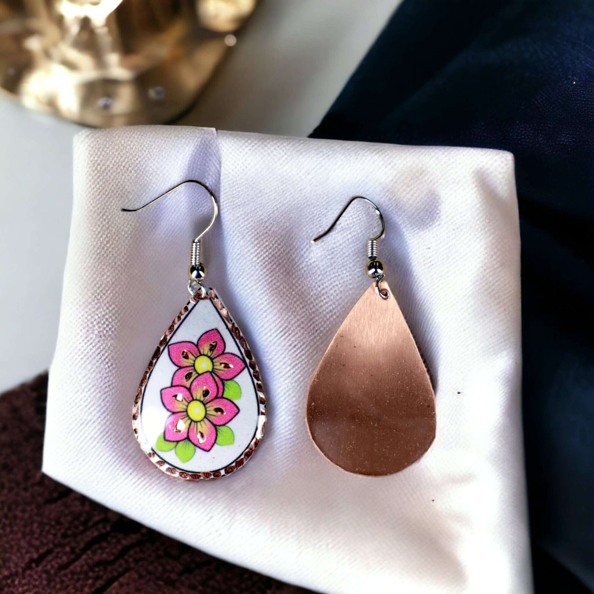 Close-up of the copper texture on handcrafted pink flower copper drop earrings