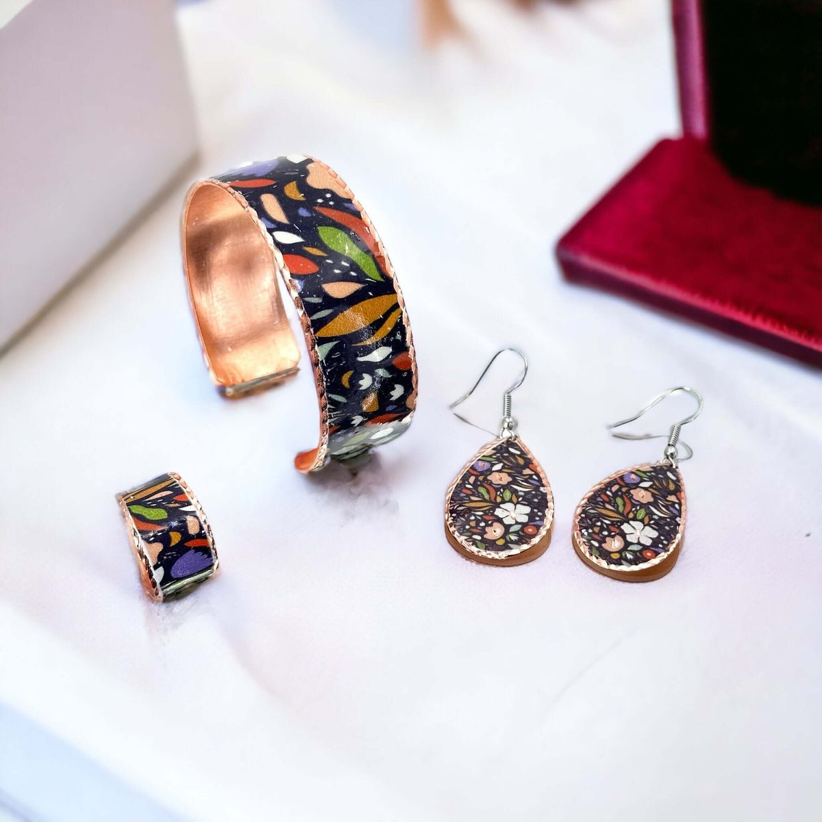 Individual pieces from three-piece purple and white flowers copper jewellery set arranged together
