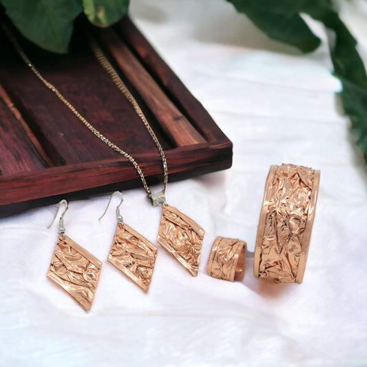 The full handcrafted wrinkled copper jewellery set laid flat