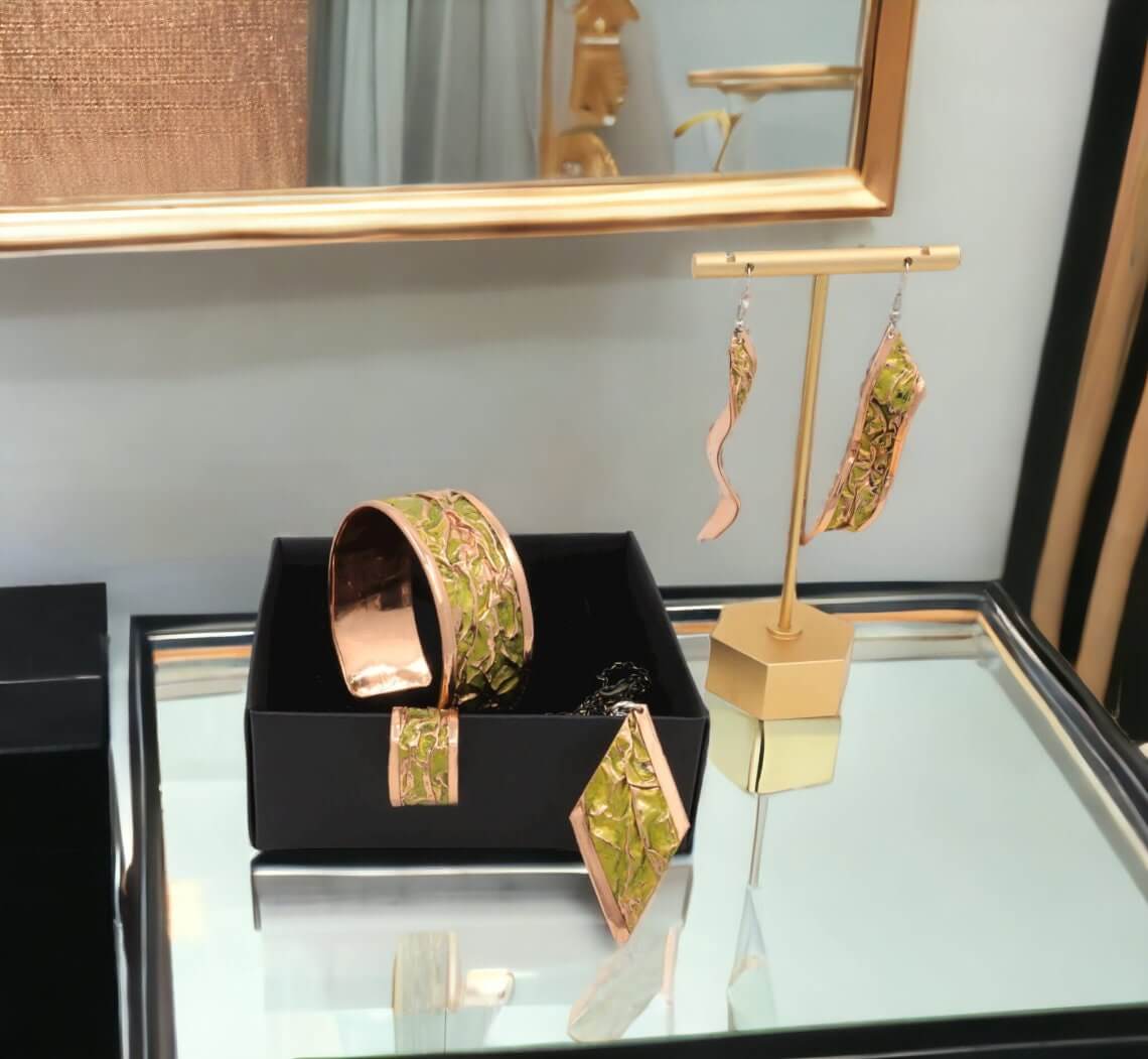 Individual pieces from four-piece yellow wrinkled copper jewellery set arranged together