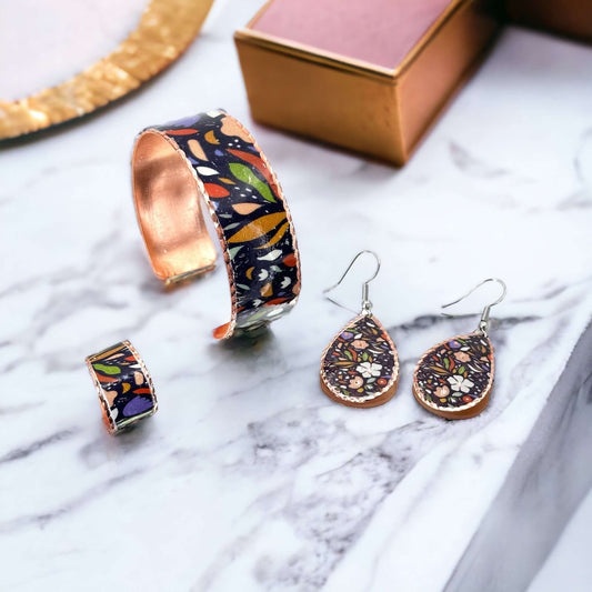 The full three-piece purple and white flowers copper jewellery set laid flat
