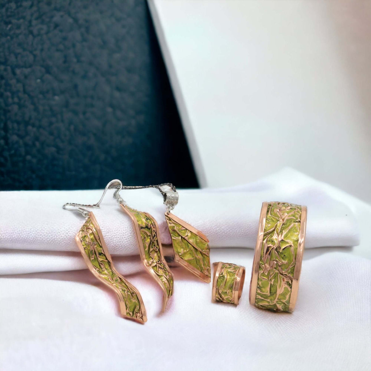 The full four-piece yellow wrinkled copper jewellery set laid flat
